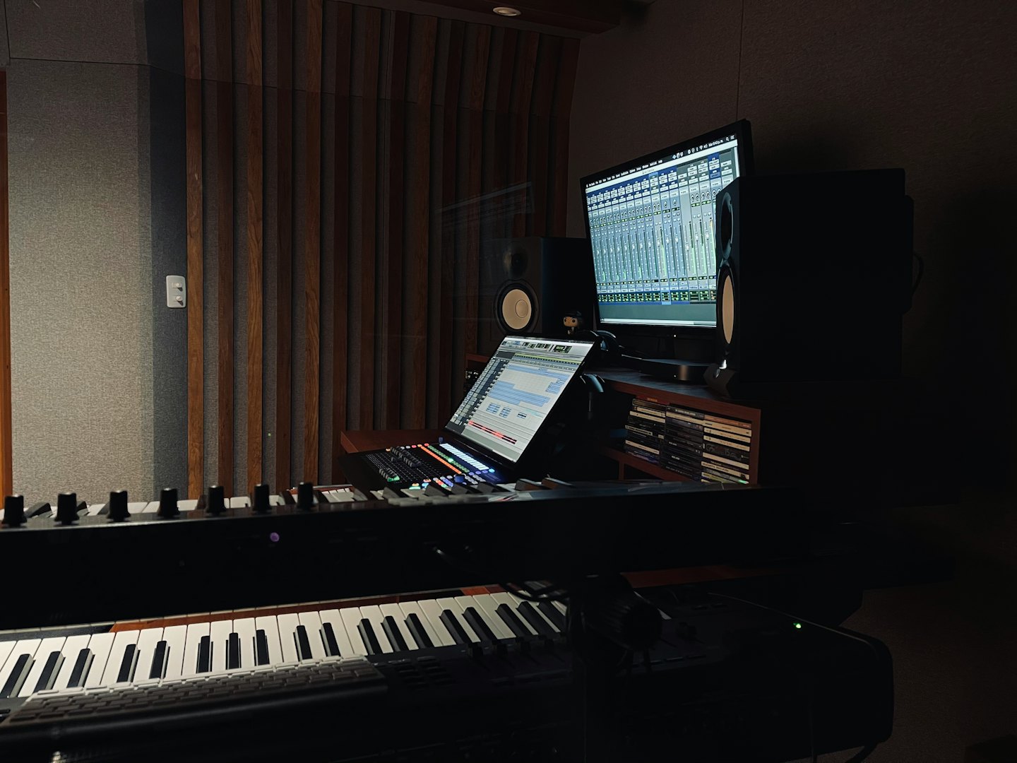 MIDI keyboard controller and laptop in a professional recording studio.